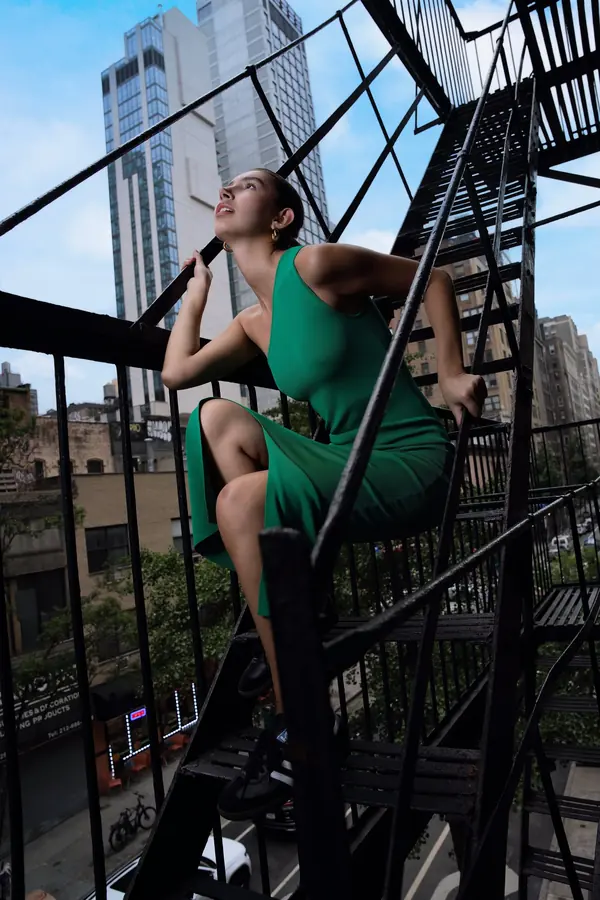 Woman in a green dress on a Manhattan fire escape