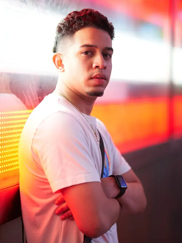 Young man lit by colorful neon signs